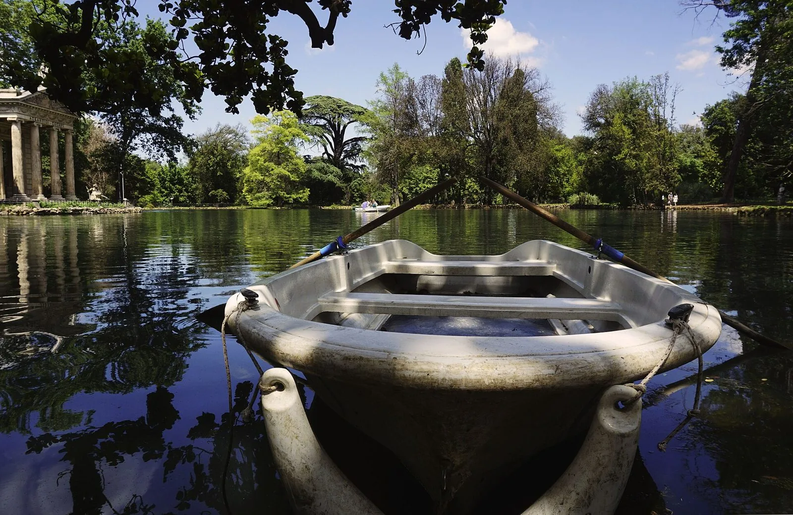 Una barca a remi sul laghetto di Villa Borghese con il tempietto di Esculapio sullo sfondo